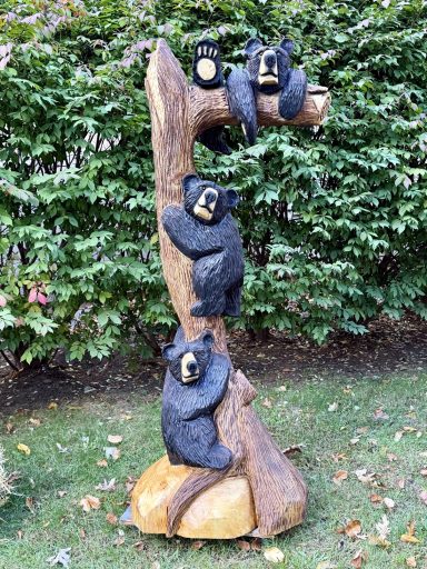Signature piece for this year's show — three black bears in a tree, carved from a single huge pine log. 6' tall. Three black bears in a tree, signature piece, 6 feet tall