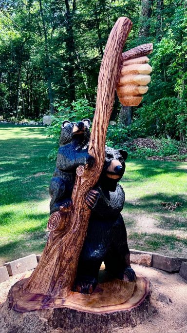 Momma bear and cub, carved from an oak stump in Pascoag, RI. The cub climbs with momma's help while she keeps a watchful eye out. Momma bear and cub carved from an oak stump, close front view